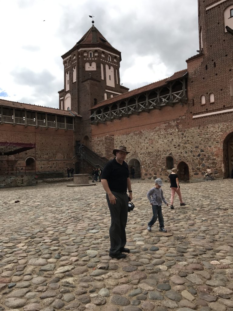 a man standing in front of a brick building