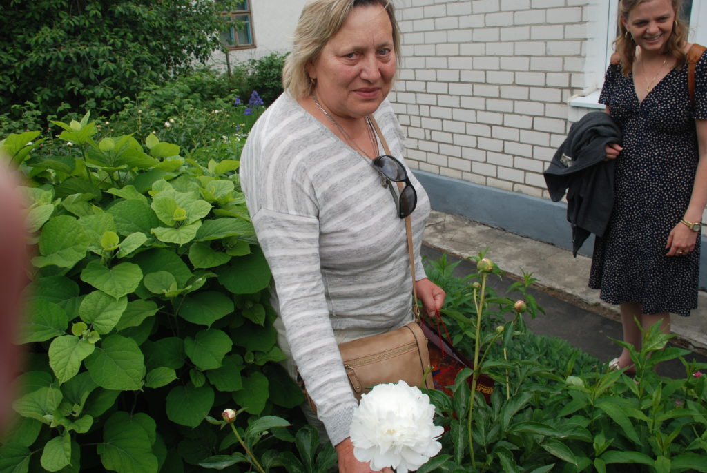 a woman standing next to a plant