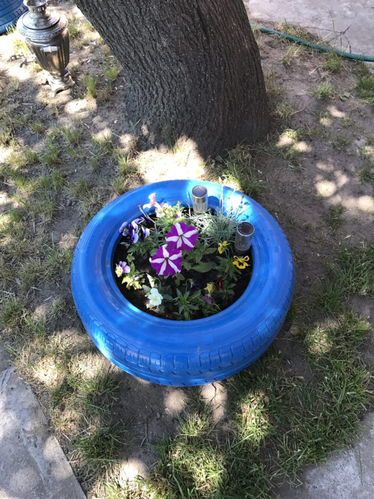a blue tire planter with flowers in it