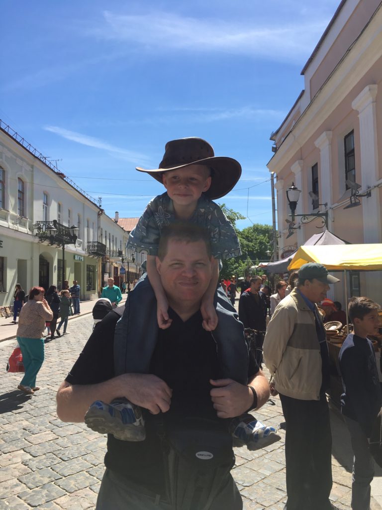 a man carrying a child on his shoulders