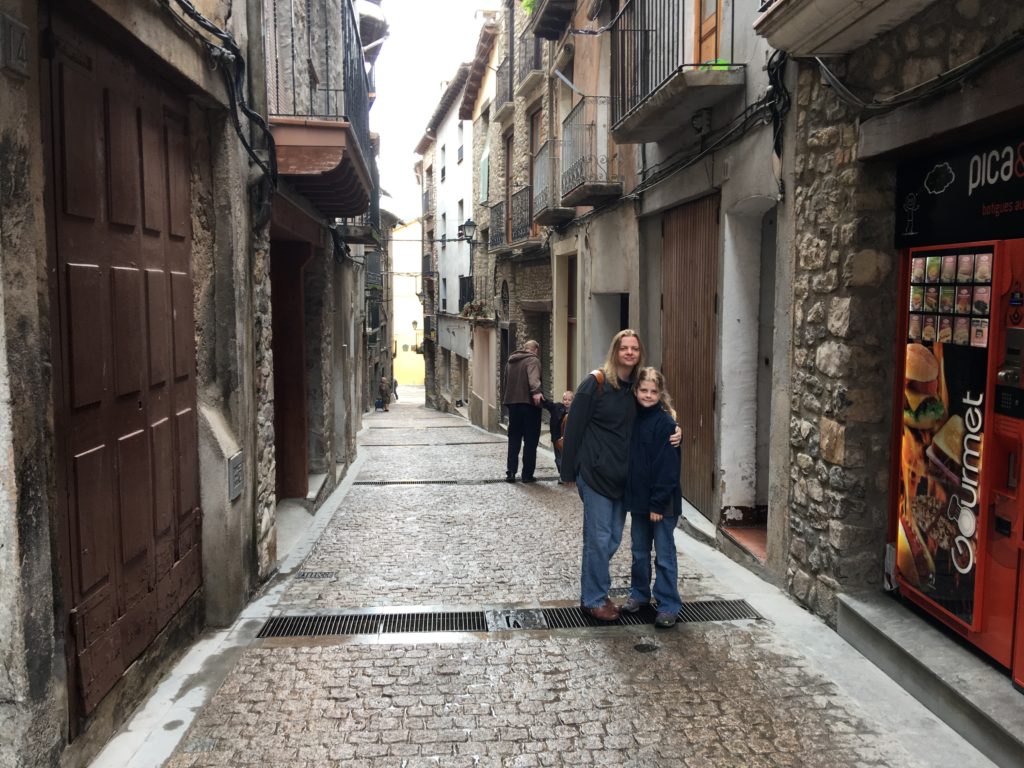 a man and a girl standing in a narrow alley between buildings