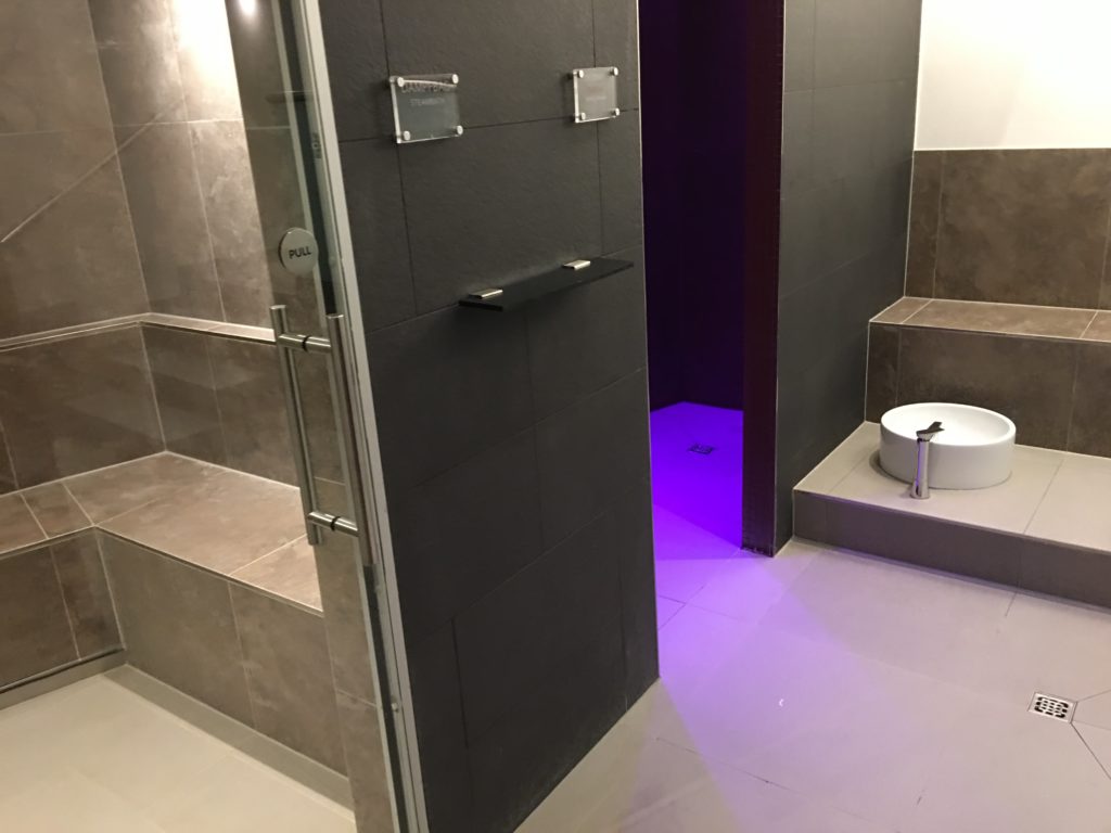 a bathroom with a shower and purple light