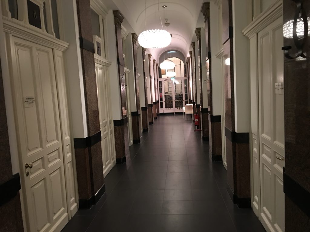 a hallway with white doors and a light from the ceiling