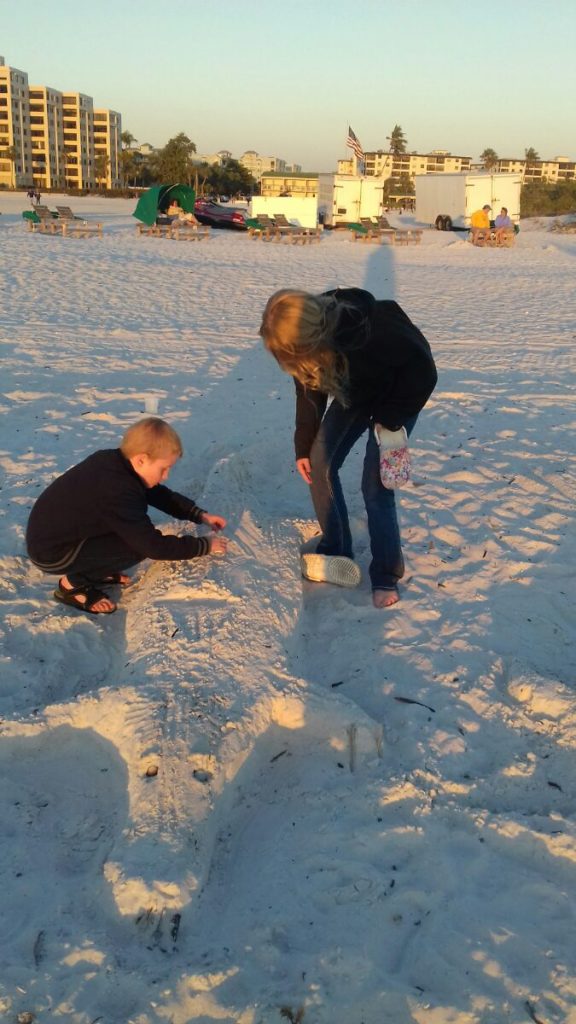 a woman and a boy playing in the sand
