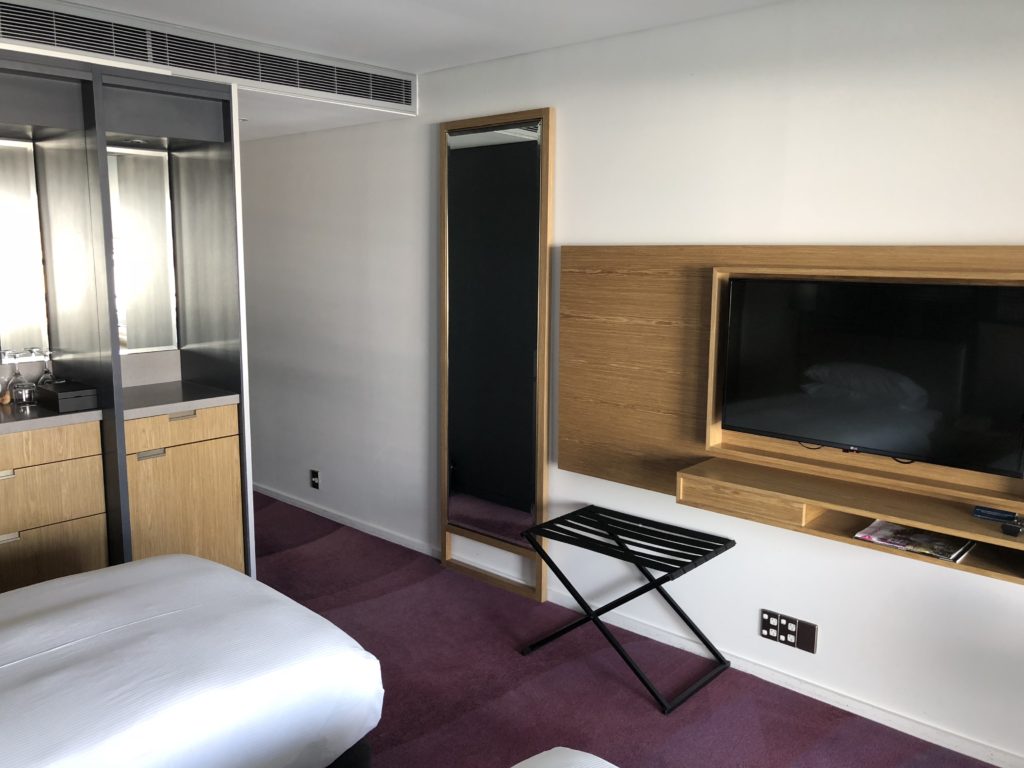 a room with a tv and a mirror