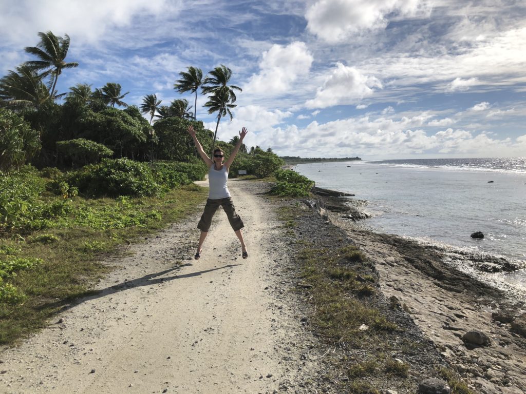 a woman jumping on a path near water