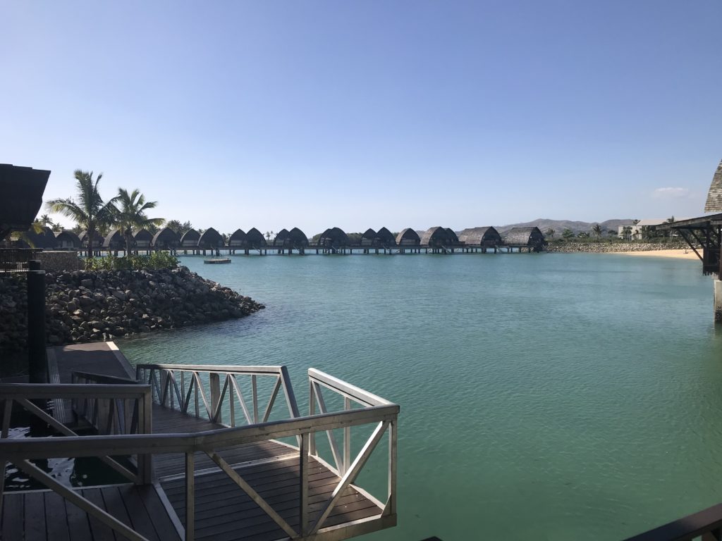 a body of water with a dock and huts