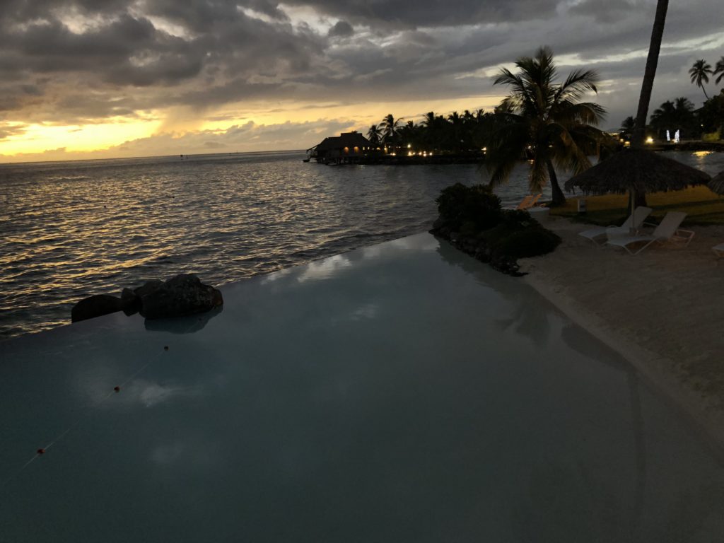 a pool with a beach and palm trees