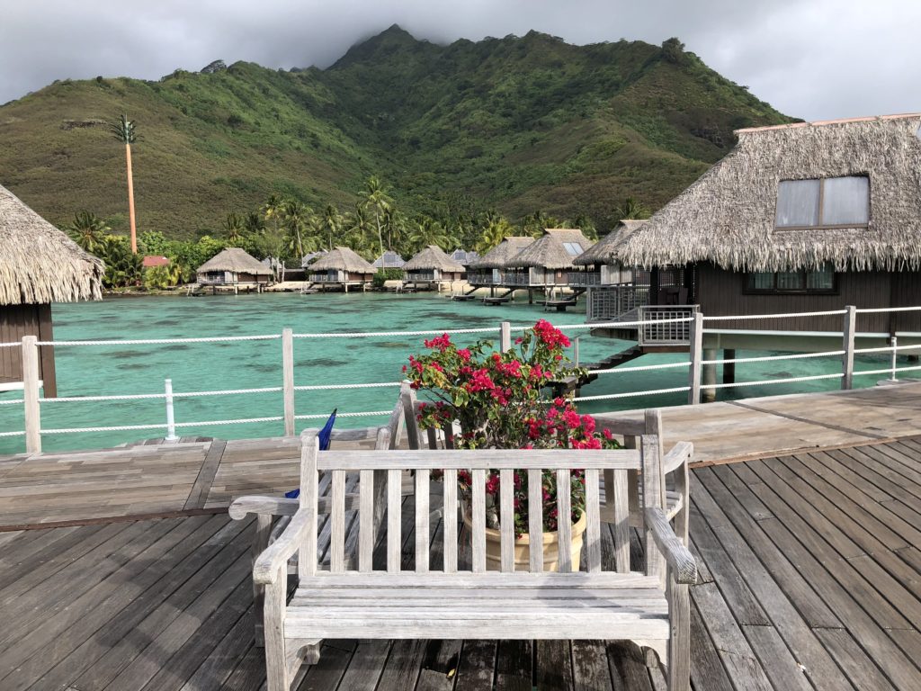 a wooden bench on a dock with a mountain in the background