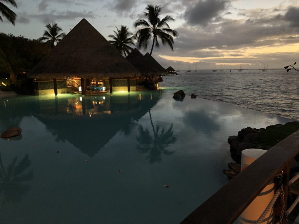 a pool with a bar and palm trees in the background