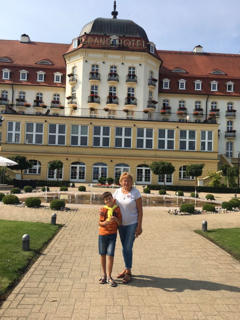 a woman and boy posing for a picture in front of a large building