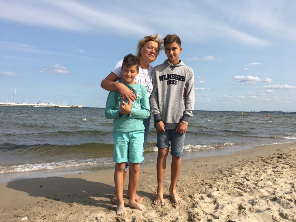 a woman and two boys on a beach