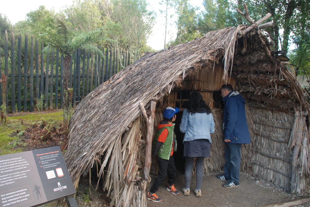a group of people standing in a straw hut