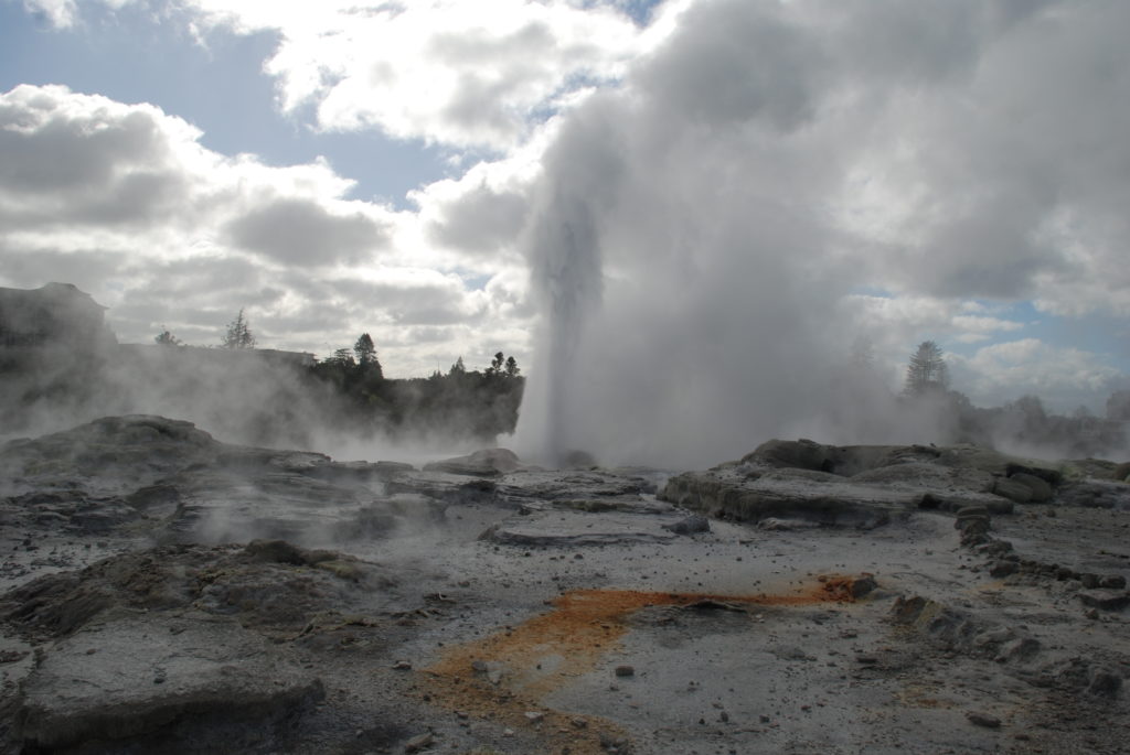 a geyser erupting in a valley