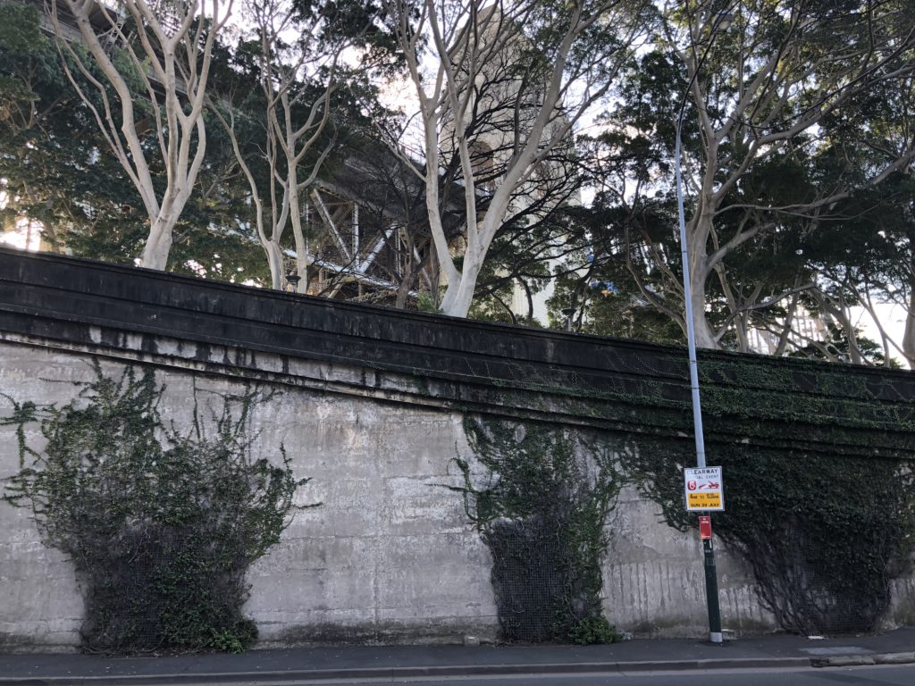 a street sign on a wall with trees in the background