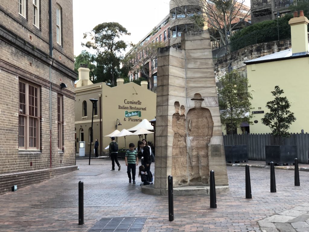 a group of people walking around a stone monument