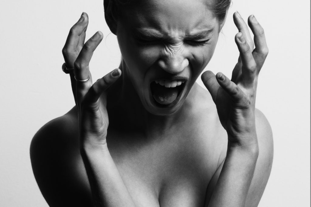 a woman with her mouth open and hands in front of her