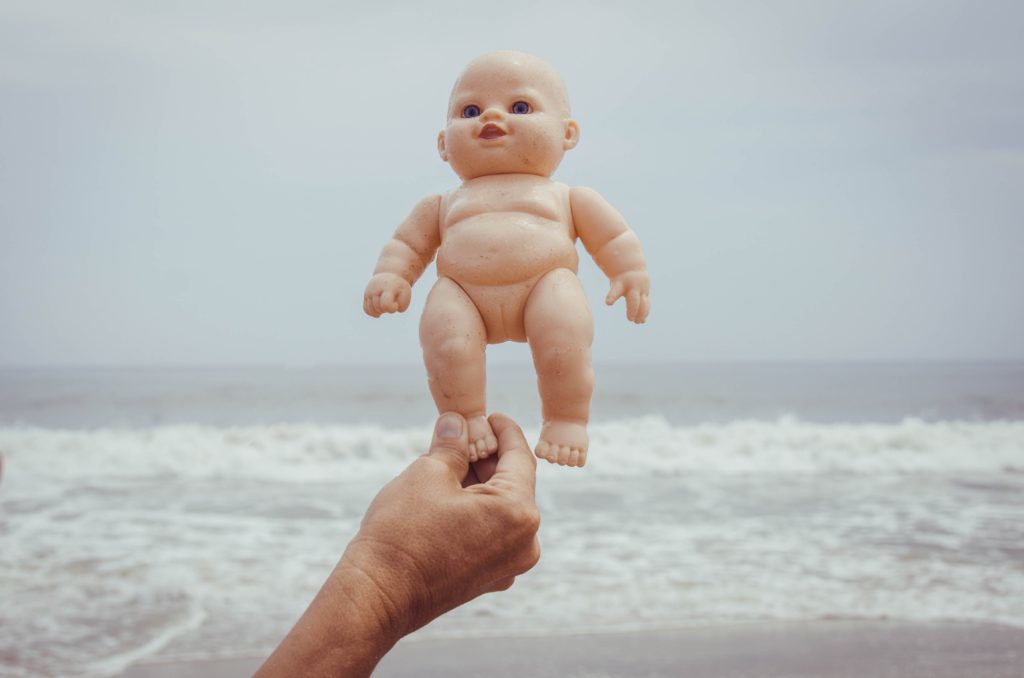 a hand holding a baby doll