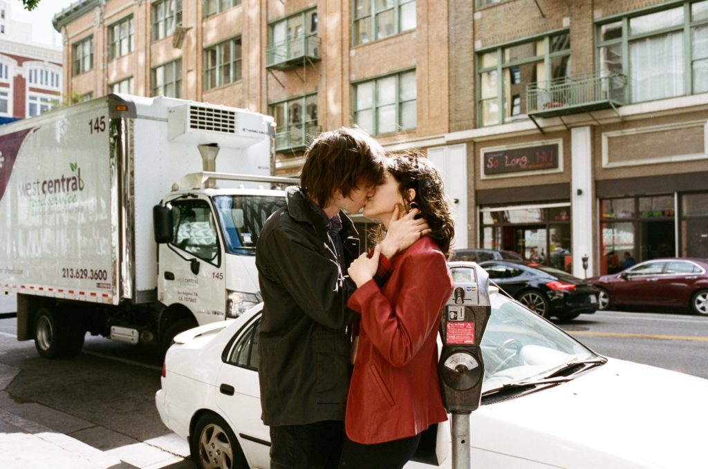 a man and woman kissing on a street
