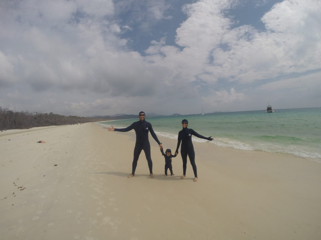 a group of people posing for a picture on a beach
