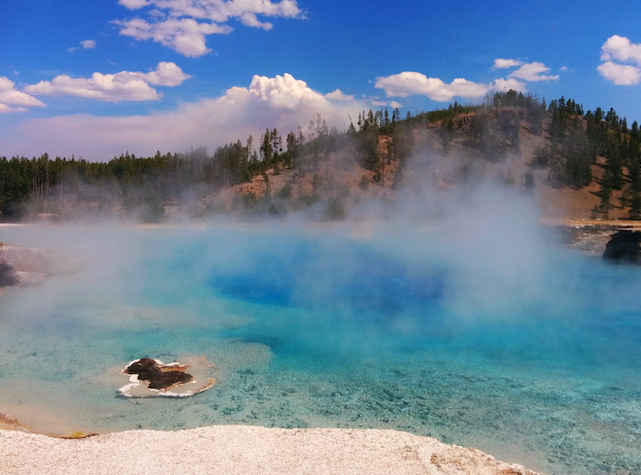 a blue water with steam coming out of it
