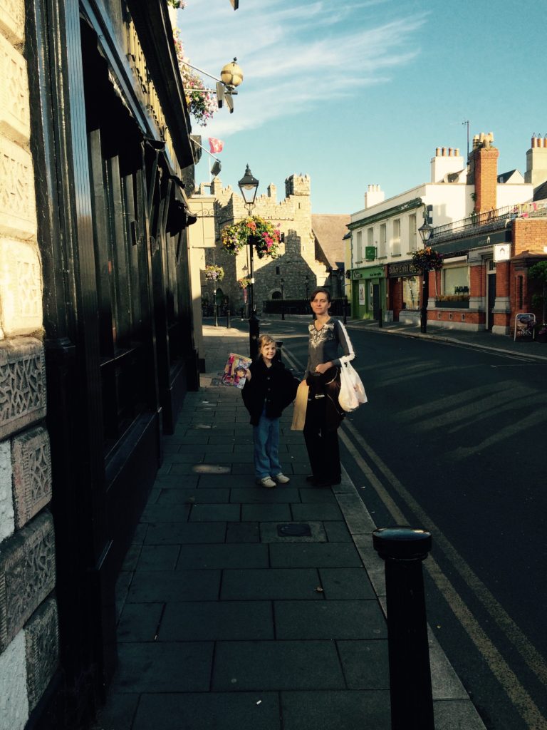 a woman and child standing on a sidewalk
