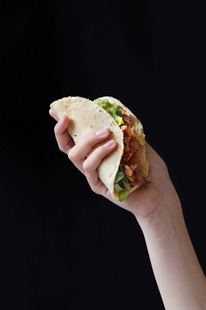 a person holding a taco