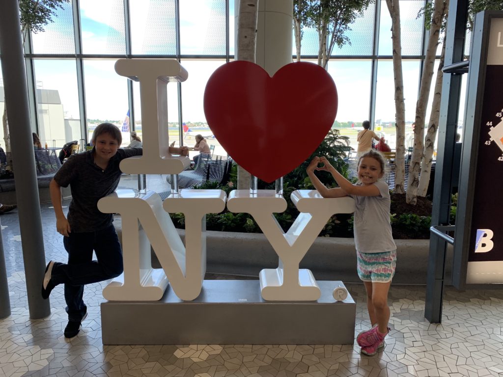 a boy and girl posing in front of a large sign