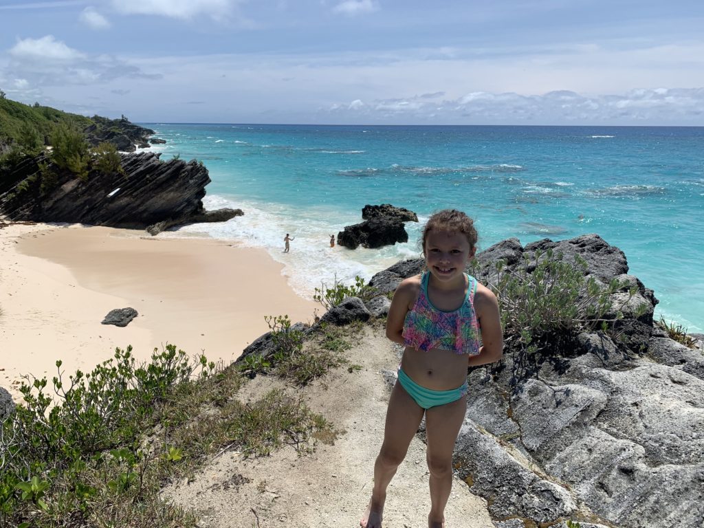 a girl standing on a rocky beach