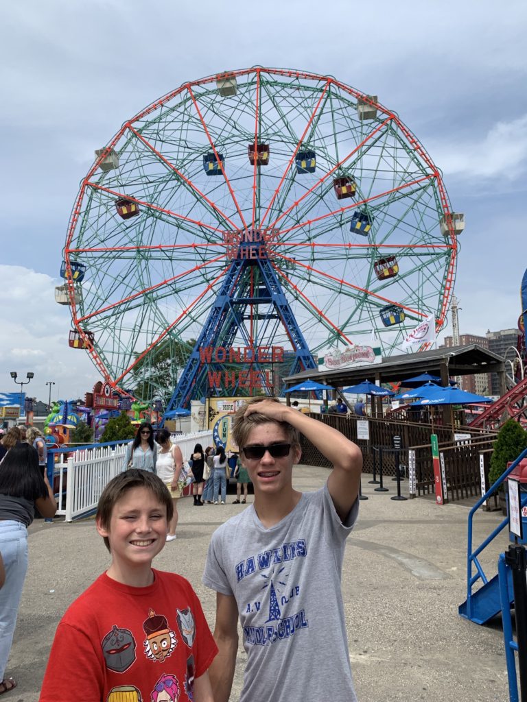a group of people posing for a picture in front of a ferris wheel