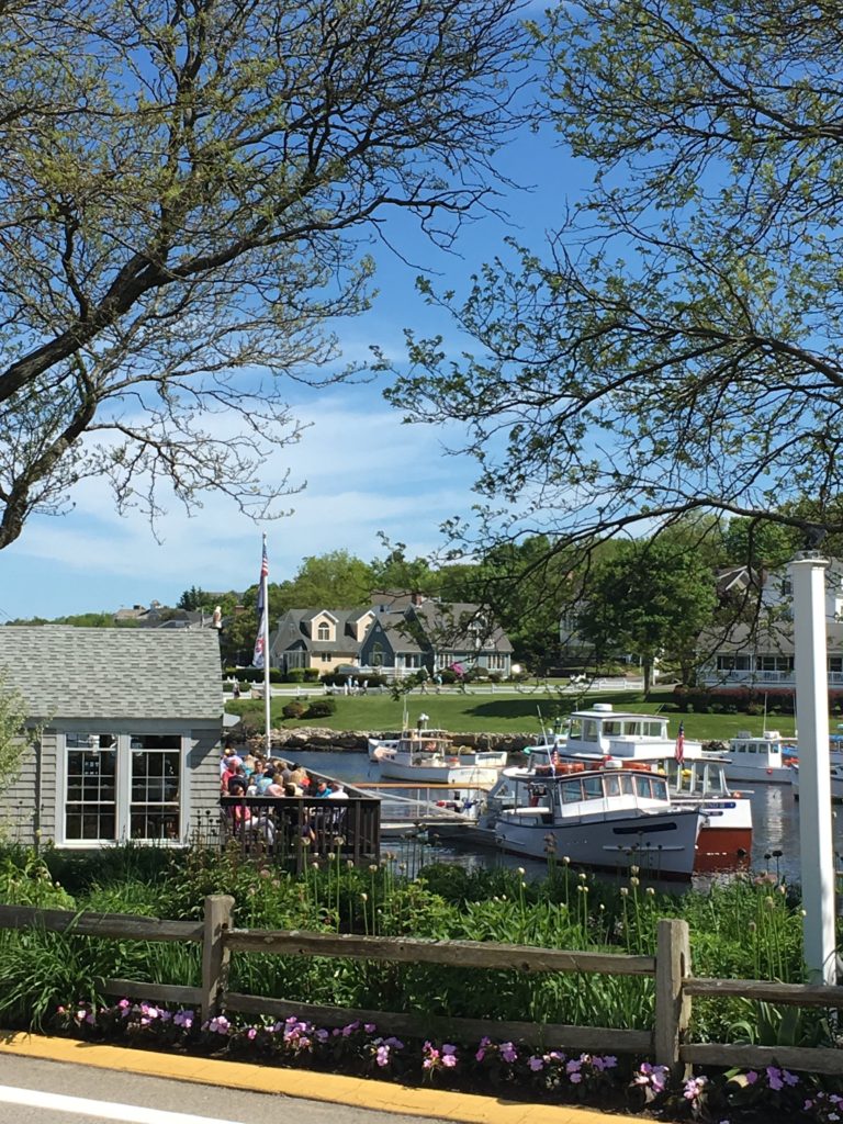 a group of people on a dock with boats in the water