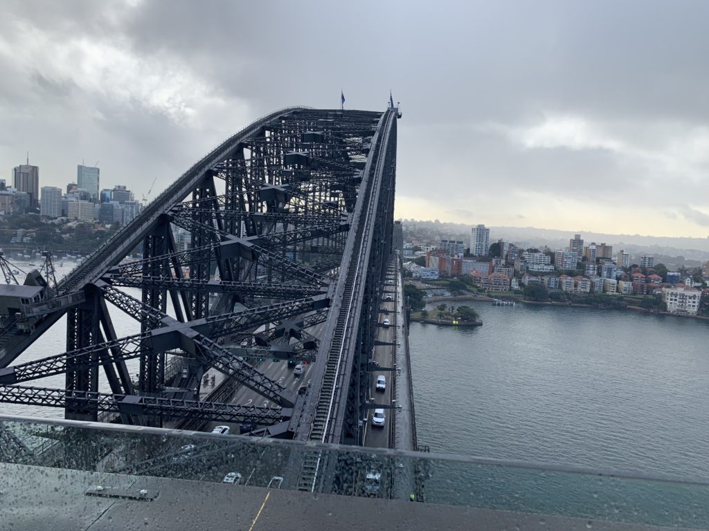 a bridge over water with cars and buildings in the background