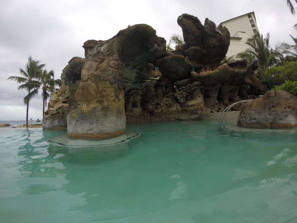 a pool with rocks and a building