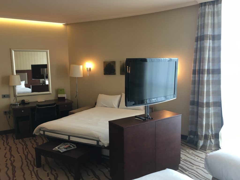 a room with a bed and a television