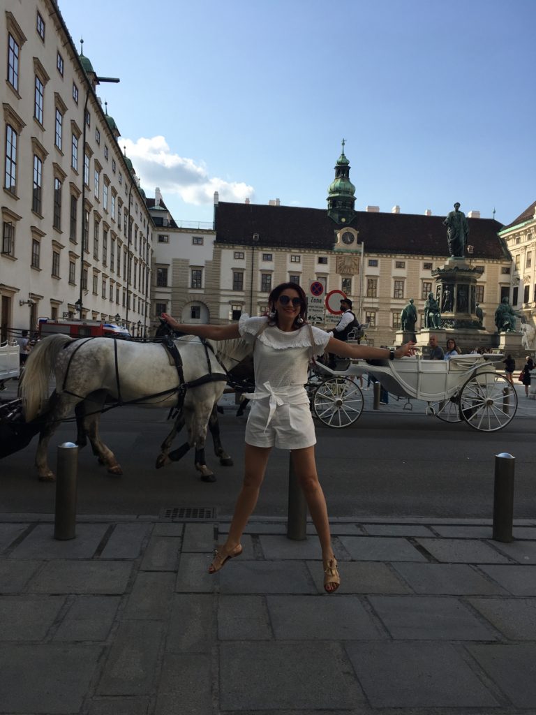a woman posing for a picture with a horse carriage