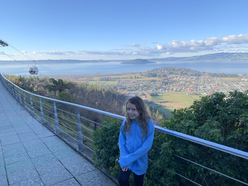a girl standing on a balcony overlooking a city