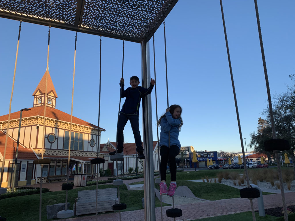 a boy and girl on a playground equipment