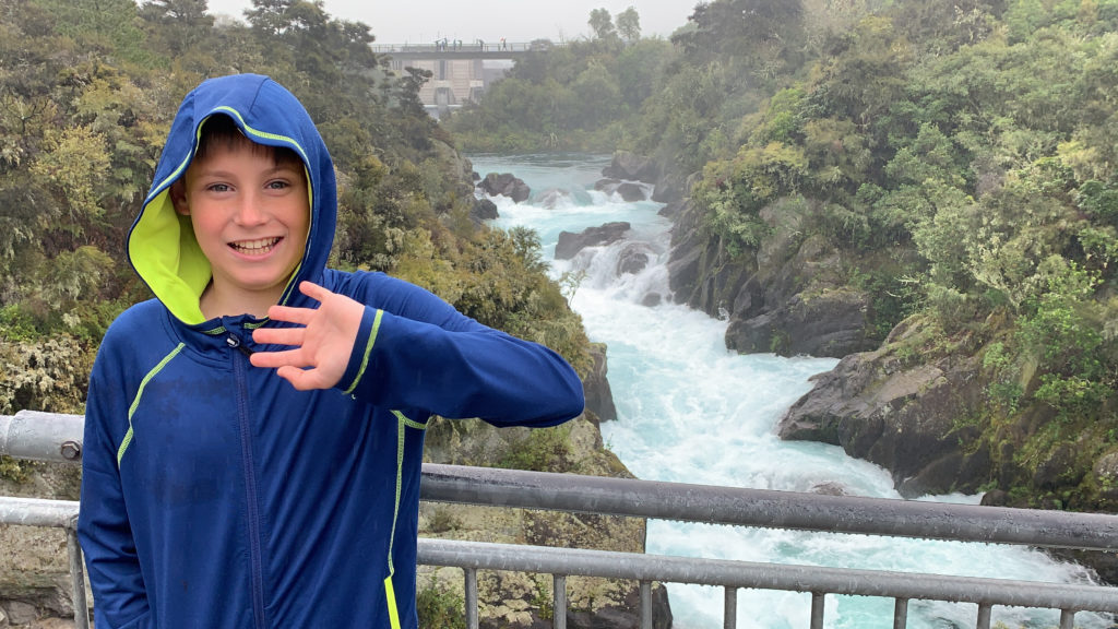 a boy standing in front of a river