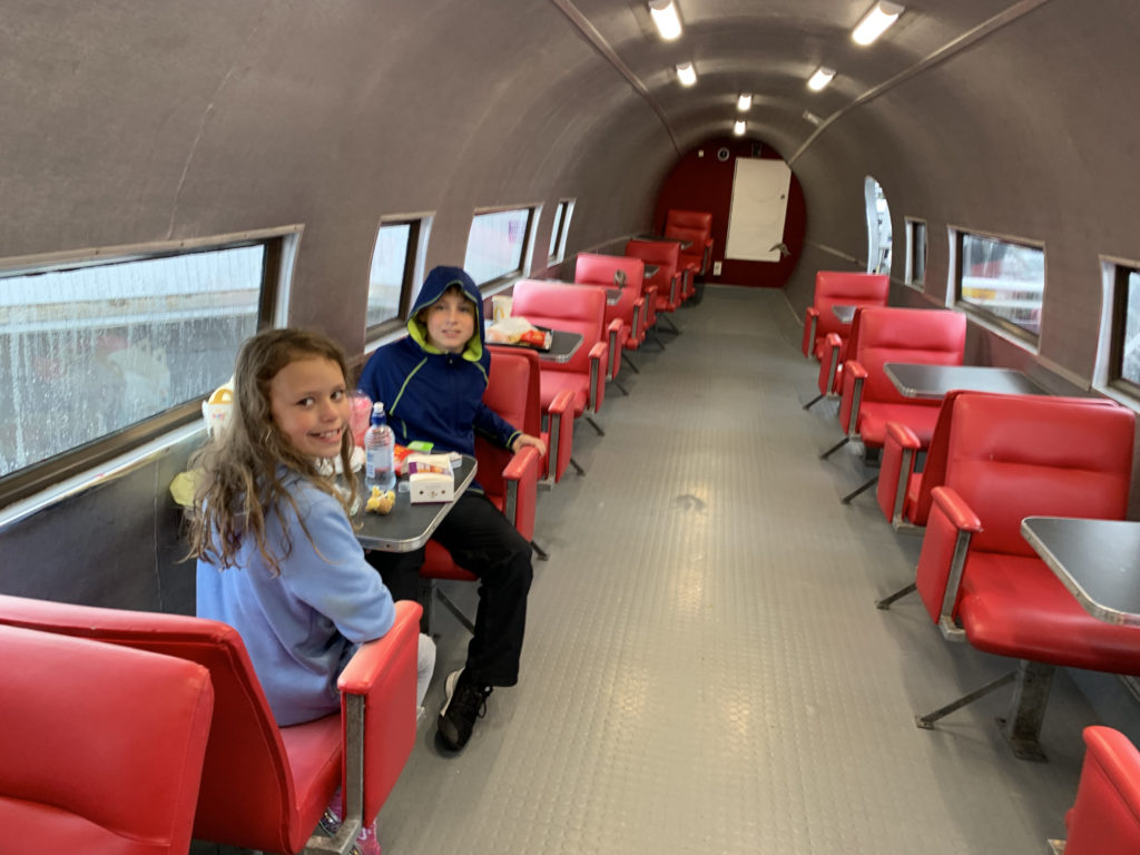 a couple of kids sitting at a table in a train