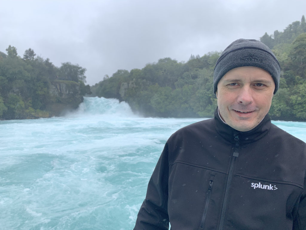 a man standing in front of a waterfall