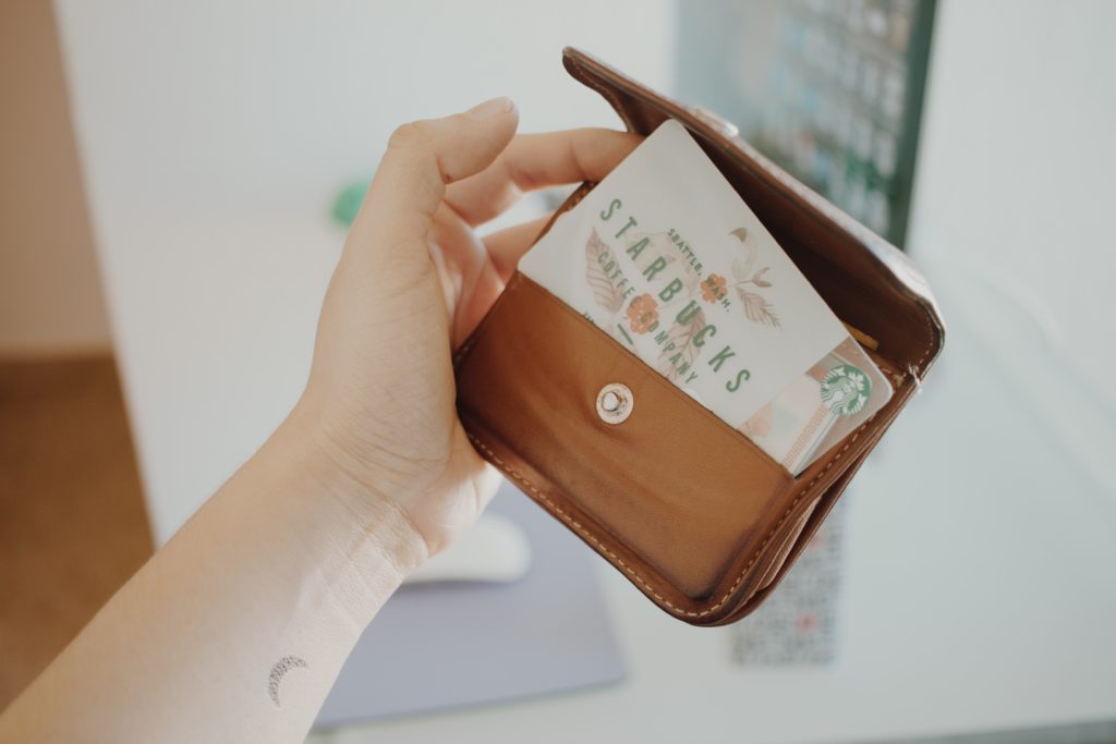 a hand holding a wallet with a card inside