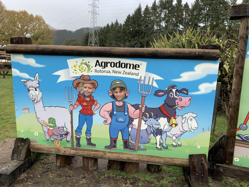 a sign with a picture of a boy and farm animals