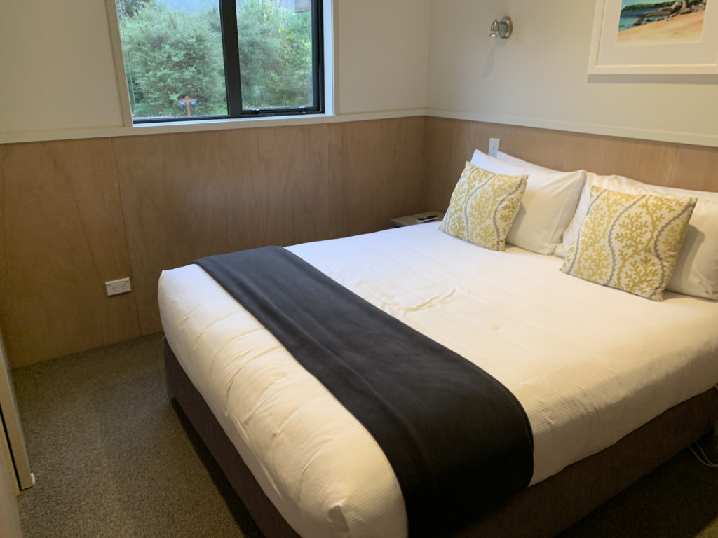 a bed with pillows and a window