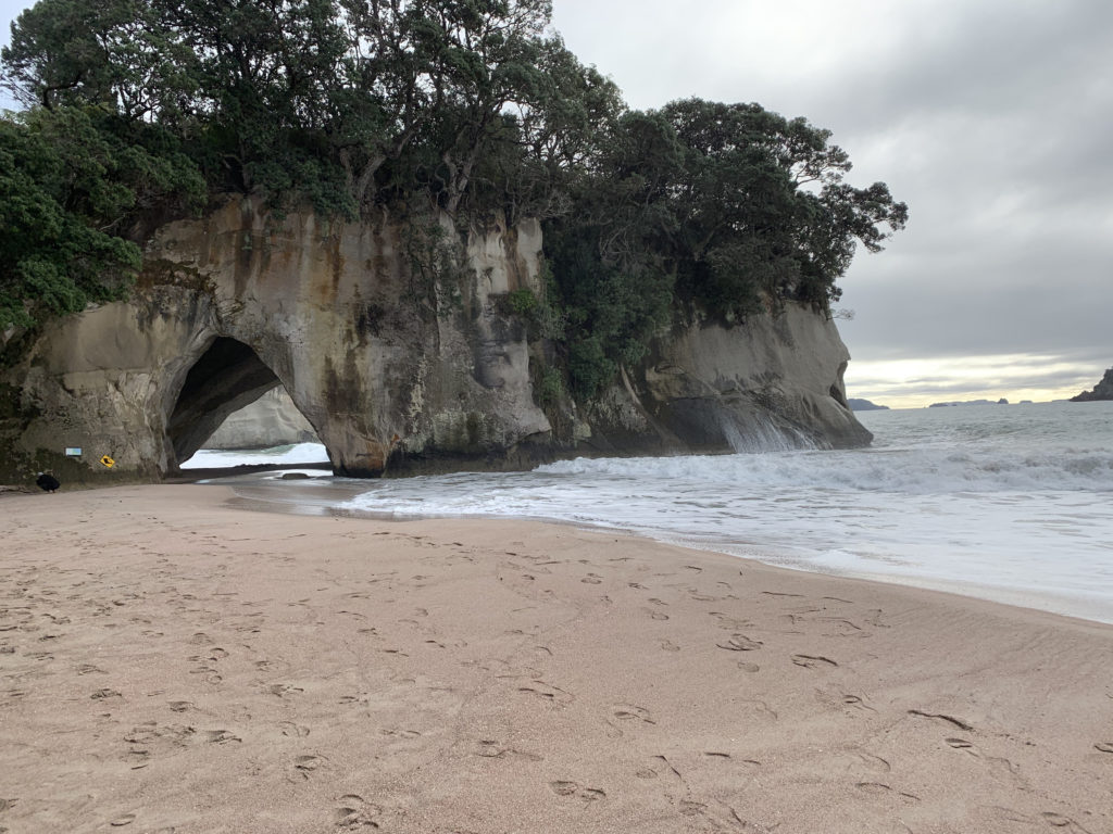 a beach with a cave on the side