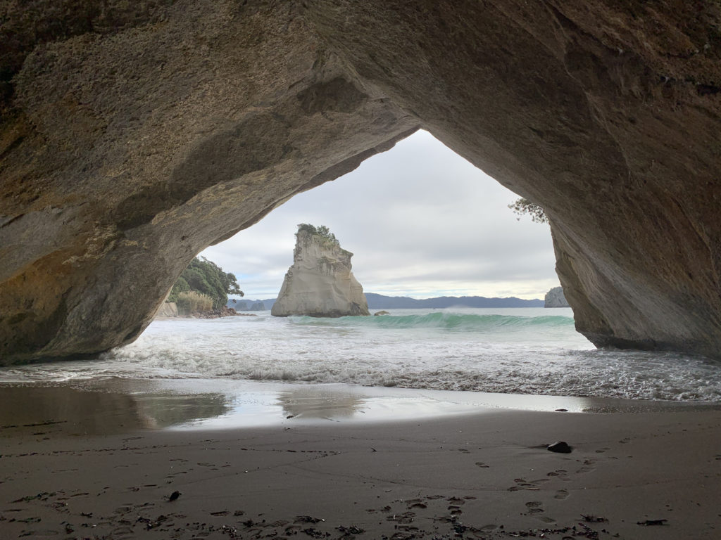 a cave with water and rocks in the background
