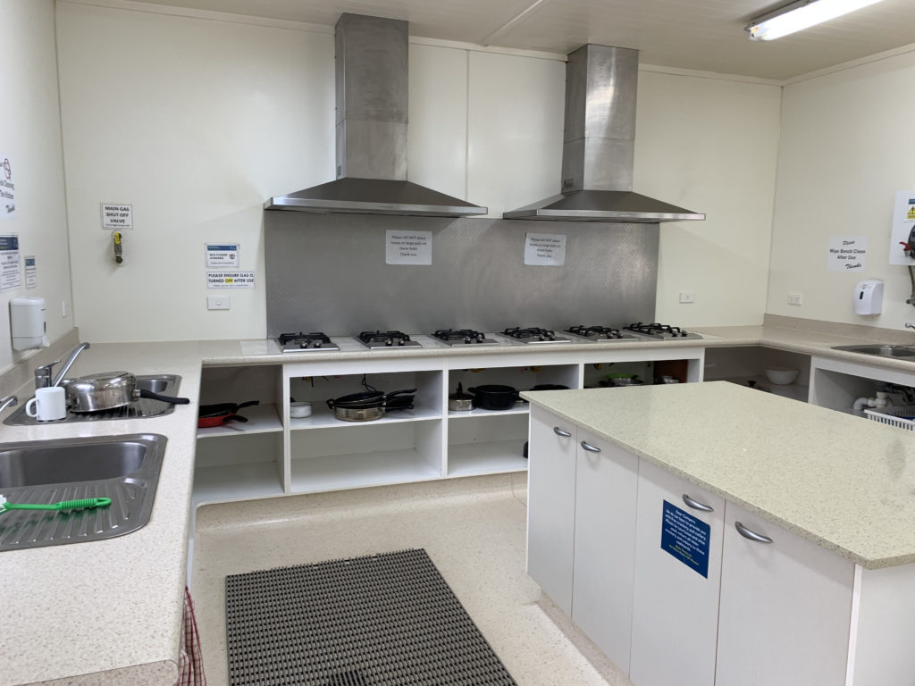 a kitchen with white cabinets and stoves