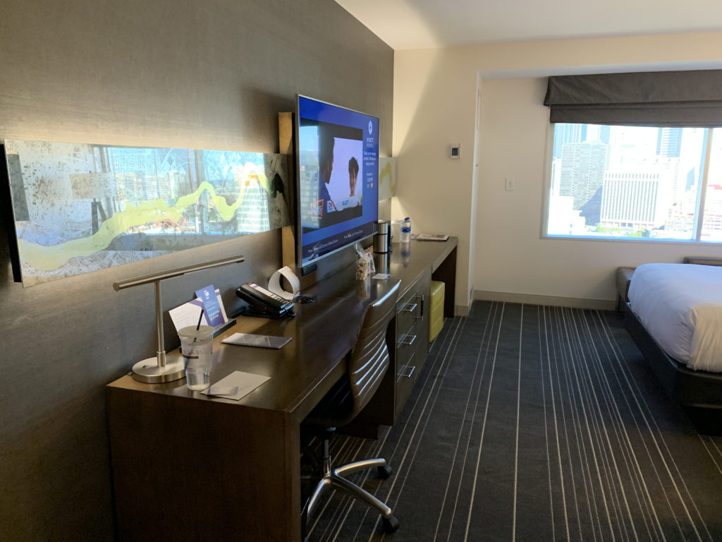 a desk with a television and a bed in a room