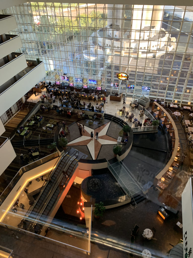 a large building with glass walls and people