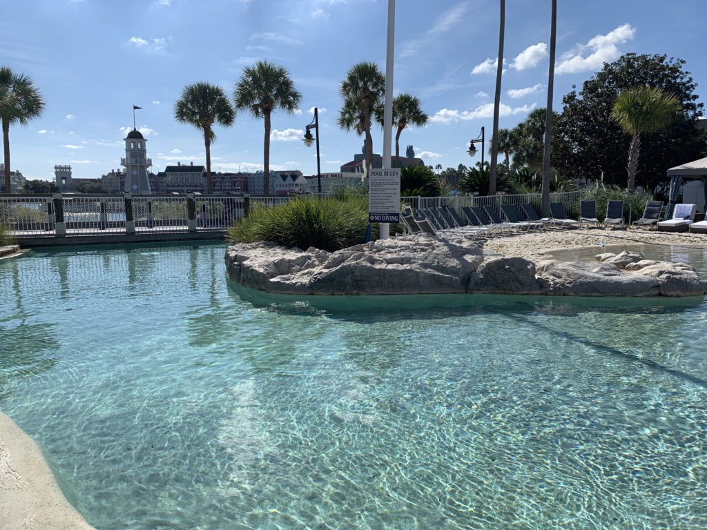 a pool with a rock island and palm trees