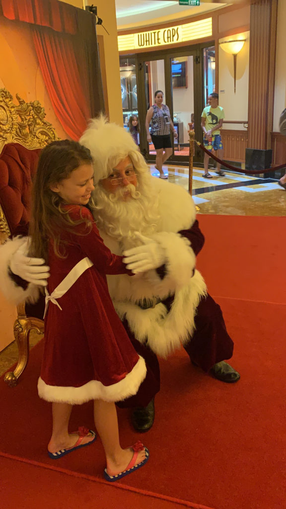 a girl hugging a santa claus